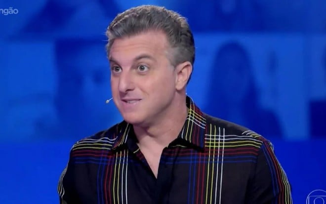 Luciano Huck com uma camisa preta no cenário do The Wall, quadro do Domingão