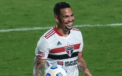 Imagem de Luciano durante jogo do São Paulo; ele está sorrindo e com o uniforme branco do clube