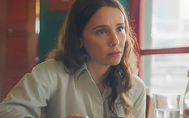Em cena de Terra e Paixão, Débora Falabella está olhando para alguém com a expressão de apreensão