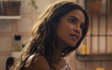 Lucy Alves com expressão séria em cena como Brisa na novela Travessia