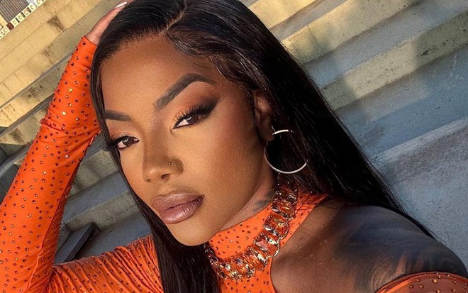 Foto de Ludmilla; ela veste roupa laranja