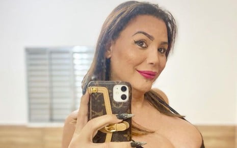 A influenciadora trans Luisa Marilac faz uma foto em frente a um espelho