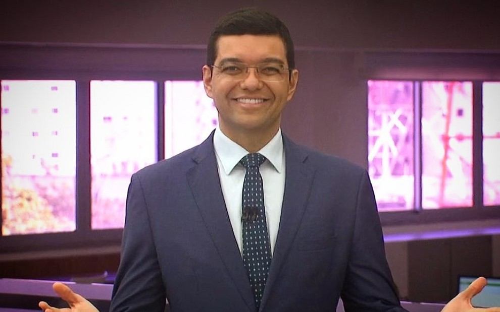 Luiz Esteves com um terno e gravata cinza e sorridente no comando do CE1