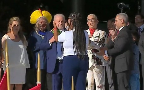 Imagem de Lula recebendo a faixa de presidente das mãos de representantes do povo
