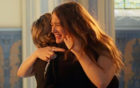 Luna e Helena choram abraçadas em uma igreja na novela Salve-se Quem Puder