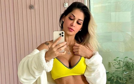Maíra Cardi de top amarelo em selfie no espelho
