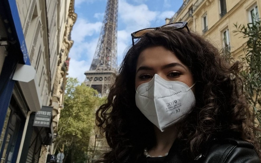 Imagem de Maisa Silva de máscara em Paris; ao fundo está a Torre Eiffel