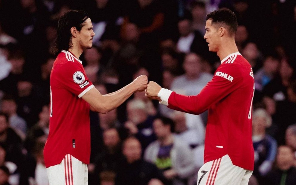 Jogadores Cavani e Cristiano Ronaldo, do Manchester United, tocando as mãos em comemoração à um gol feito