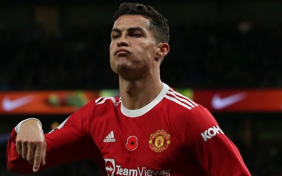 Cristiano Ronaldo, do Manchester United, veste uniforme vermelho e comemora gol apontando para baixo