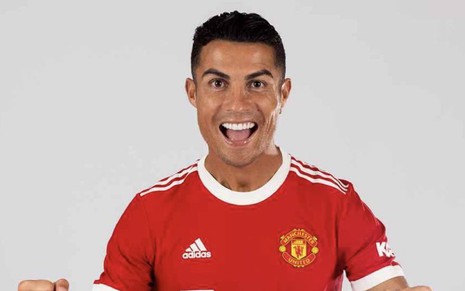 Cristiano Ronaldo com a camisa vermelha do Manchester United, vibrando para a câmera