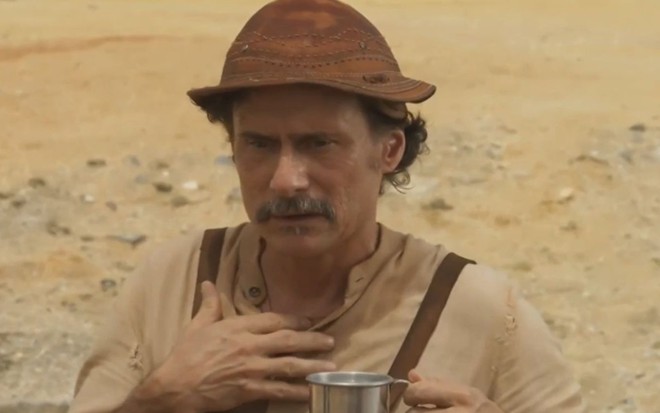 Enrique Diaz com expressão séria em cena como Timbó na novela Mar do Sertão