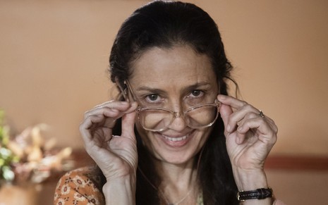 Cyria Coentro posa nos bastidores de Mar do Sertão segurando óculos