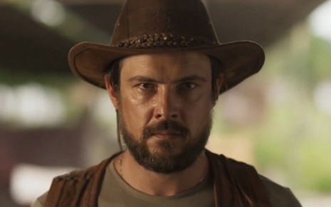 Sergio Guizé usa chapéu de caubói e está com expressão séria em cena como José Mendes na novela Mar do Sertão