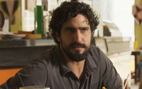 O ator Renato Góes em cena como Tertulinho, com expressão séria, na novela Mar do Sertão