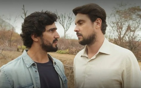 Os atores Renato Góes e Sergio Guizé como Tertulinho e Zé Paulino em Mar do Sertão; eles estão se olhando frente a frente com cara de raiva