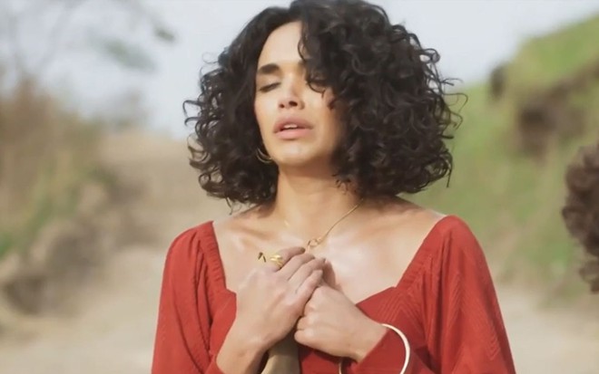 A atriz Giovana Cordeiro como Xaviera em Mar do Sertão; ela está com os olhos fechados e as mãos cruzadas no peito, com cara de choro