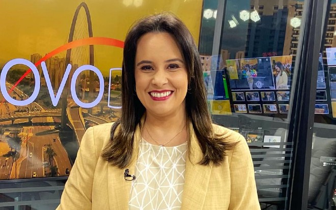 Marcela Mesquita com uma blusa amarela e sorrindo no Thati Notícias, da TV Thati/SBT