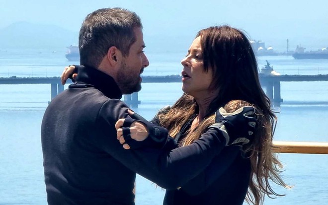 Ator Marcelo Serrado segura Paolla Oliveira pelo braço e a encara em cena de Cara e Coragem, novela das sete da Globo