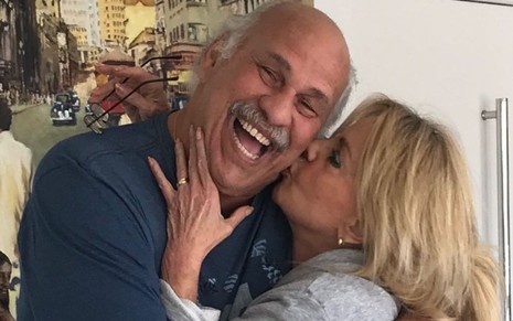 Márcio Canuto sorri ao receber beijo na bochecha da mulher, a ex-miss Alagoas Libia Mafra