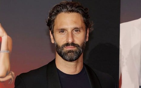 Marco Calvani veste terno e posa para foto durante a premiere de Alerta Vermelho, filme da Netflix