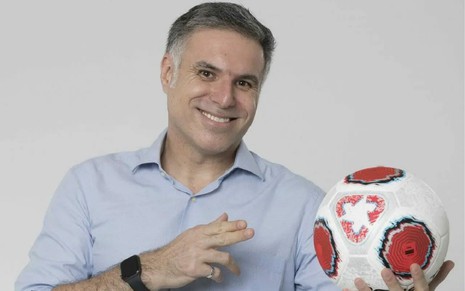 Marco de Vargas segura uma bola e sorri em uma foto de divugação