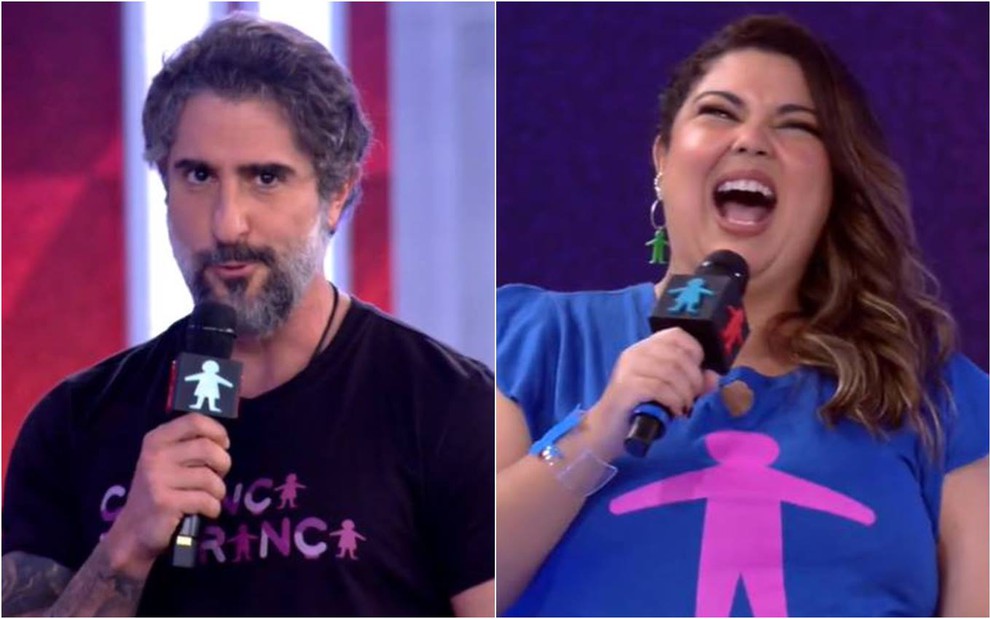 Marcos Mion olha para frente, veste camiseta preta e segura um microfone; Fabiana Karla dá risada, segura microfone e veste camiseta azul