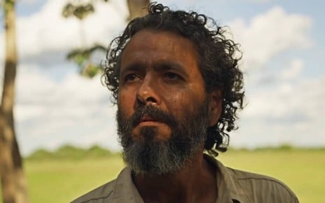 Marcos Palmeira com uma camisa cinza e sujo durante cena de Pantanal