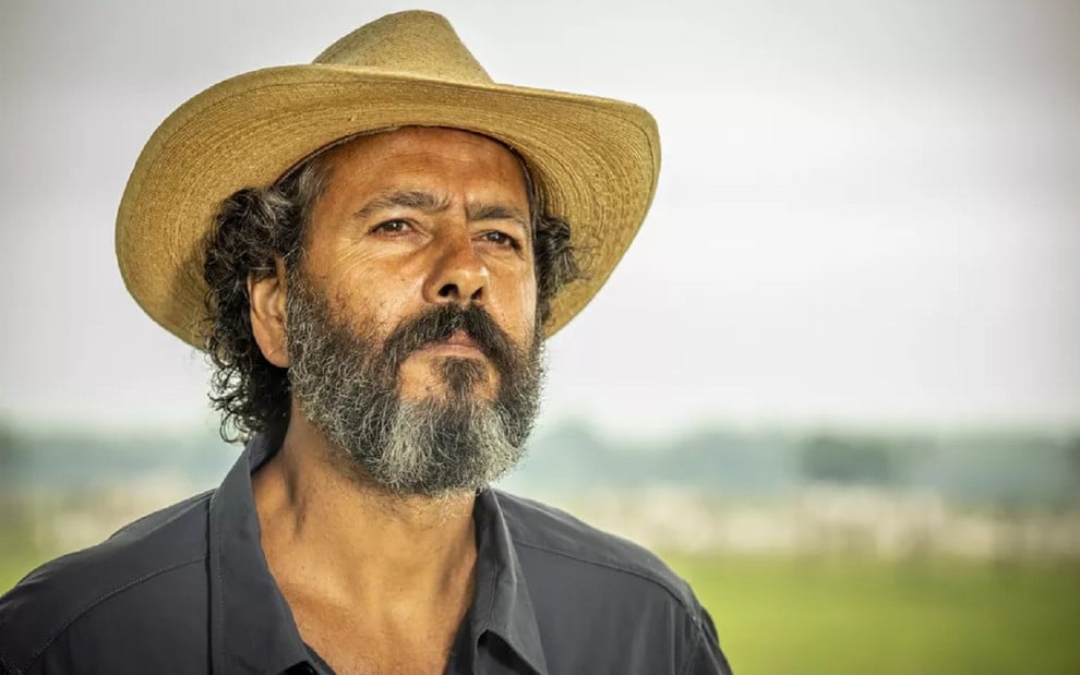 Marcos Palmeira com uma camisa azul e um chapéu de cowboy durante as gravações de Pantanal no Mato Grosso do Sul