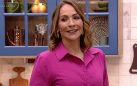 Maria Beltrão com uma blusa rosa no cenário do É de Casa