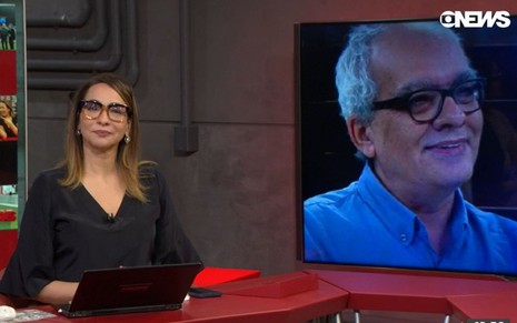 Imagem de Maria Beltrão emocionada no Estúdio I, da GloboNews, com imagem de Artur Xexéo no telão