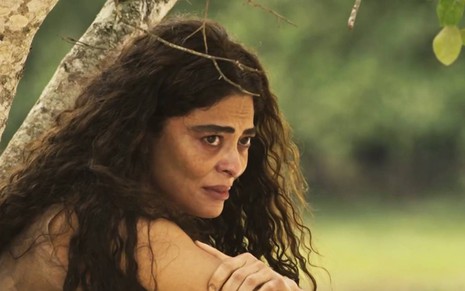 Juliana Paes cruza os braços e olha levemente para o lado com cara de preocupação em cena de Pantanal
