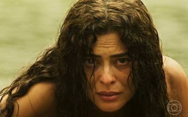 Juliana Paes molhada e com expressão séria em cena como Maria Marruá na novela Pantanal