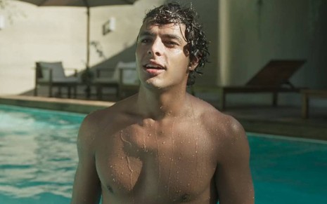 Ator Matheus Abreu surge sem camisa na piscina enquanto olha para cima em cena de Quanto Mais Vida, Melhor