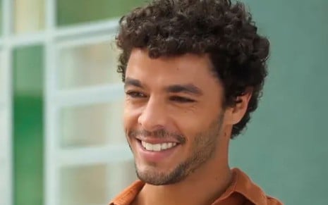 Matheus Abreu sorri em cena da novela Vai na Fé