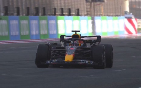 Carro de Fórmula 1 preto e amarelo, da Red Bull, sendo pilotado por Max Verstappen