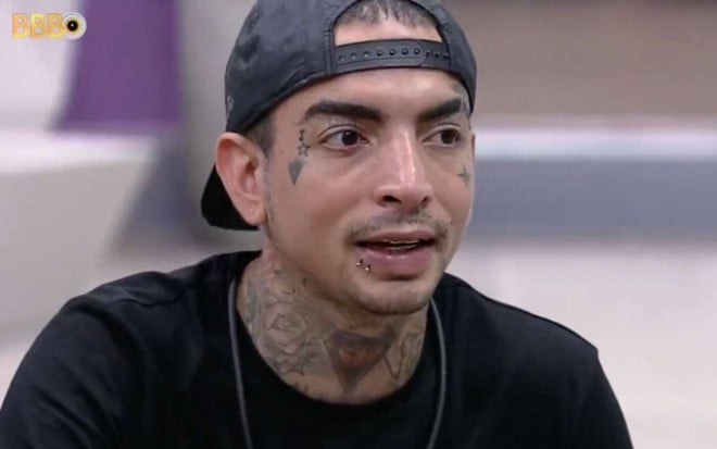 MC Guimê no BBB 23: ele usa um boné preto para trás e tem a expressão séria