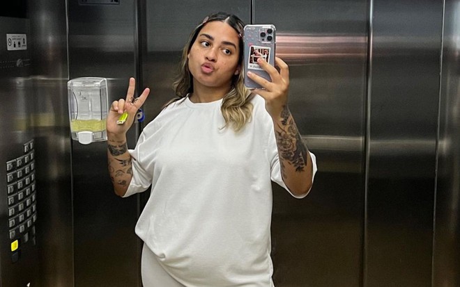 MC Loma de branco tira selfie em espelho de elevador