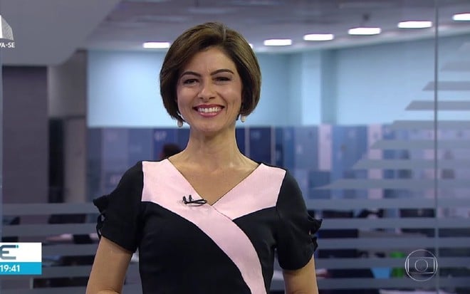 Meiry Lanunce na apresentação do NE2, com um vestido rosa e preto, e sorrindo