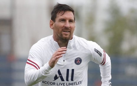 Lionel Messi correndo durante treinamento do PSG; ele está com o uniforme branco do clube