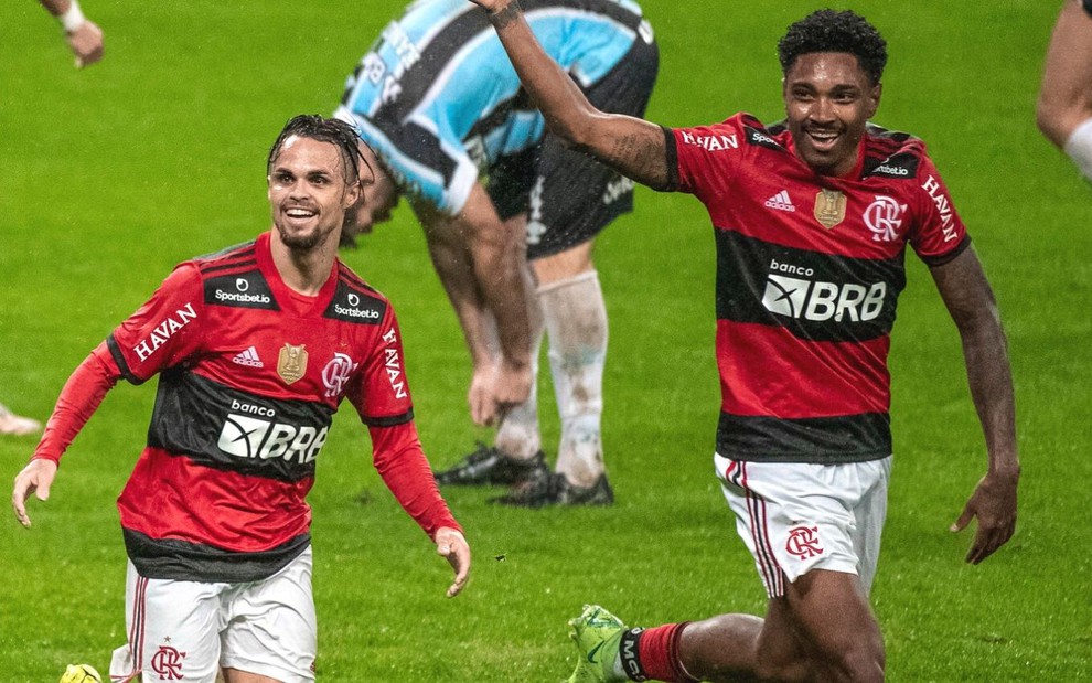 Michael e Vitinho correm enquanto comemoram gol do Flamengo contra o Grêmio; eles estão com o uniforme vermelho e preto
