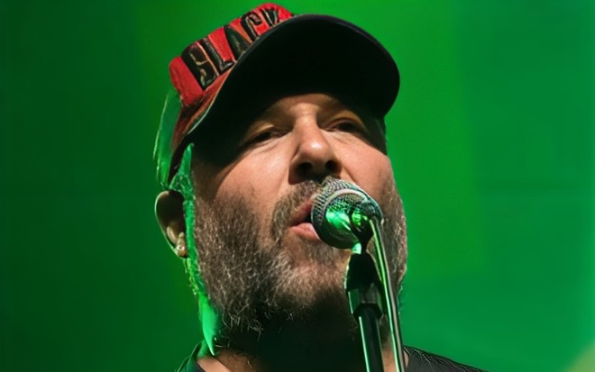 Mingau, baixista do Ultraje a Rigor, está de boné, e canta