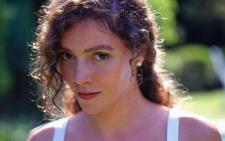 A atriz Thaís Campos caracterizada como Arlete, sua personagem em Mulheres de Areia (1993), olha para a câmera com expressão séria