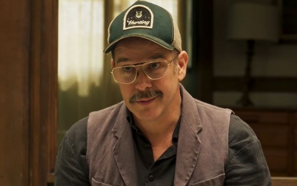 Murilo Benício usa boné e óculos de grau em cena como Tenório na novela Pantanal