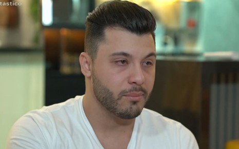 Murilo Huff está de camiseta branca e chorando em entrevista ao Fantástico, da Globo; ele é ex de Marília Mendonça