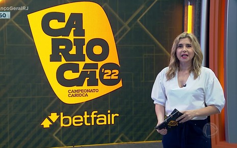 Mylena Ciribelli com uma camisa branca e lendo um comunicado da Record no Balanço Geral Rio sobre o Carioca 2022