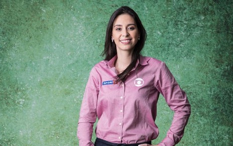 Nadja Mauad com uma blusa rosa e sorrindo em uma foto feita para a Globo
