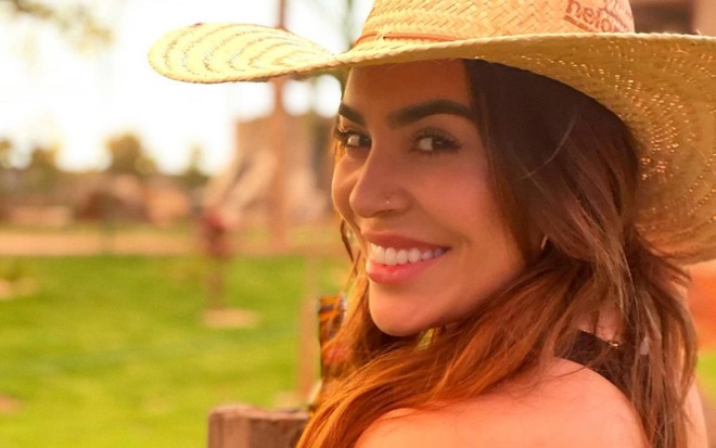 De chapéu de aba larga, Naiara Azevedo sorri para a câmera