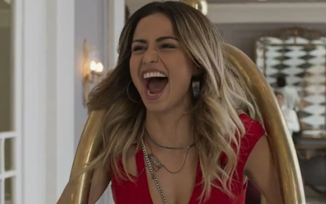 Nanda Costa está com a boca aberta e grita de felicidade em cena como Sandra Helena na novela Pega Pega