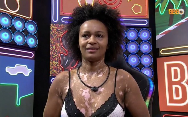 Natália Deodato sendo atendida no confessionário do BBB 22, ela está sentada, de camisola preta e branca e exibe um semblante de preocupação