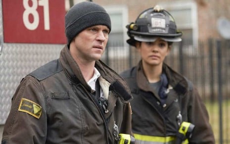 Jesse Spencer e Miranda Rae Mayo com uniformes de bombeiro em Chicago Fire